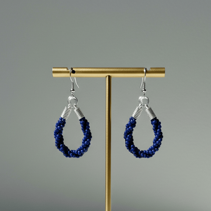Twisted Royal Blue and White Hoop Earrings on a display stand with a silver hook design