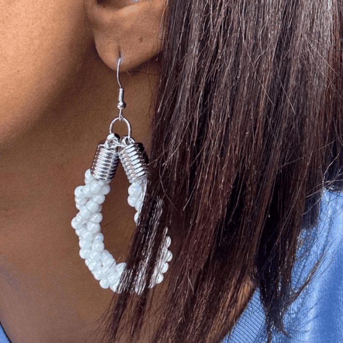 Twisted Royal Blue and White Hoop Earrings showcased on a model's ear with a stylish backdrop