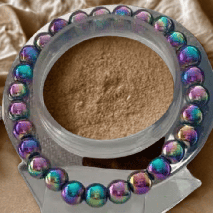 Rainbow Hematite Stone Bracelet on a round display showcasing its colorful metallic finish