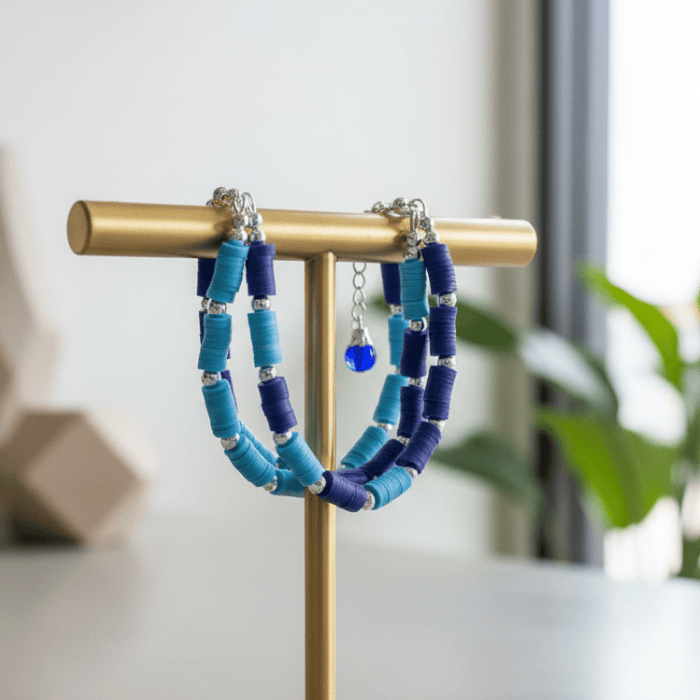 Sky and Royal Blue Three Strand Bracelet with Earrings displayed on a stand