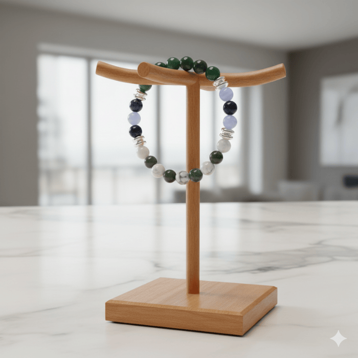 The Patience Stone Bracelet displayed on a wooden stand with various colored beads