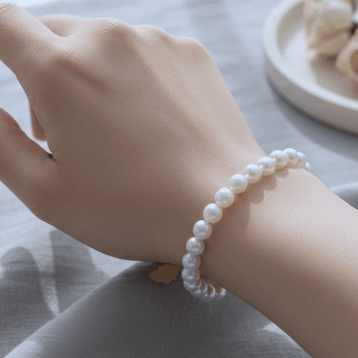 Elegant White Glass Pearl Stretch Bracelet displayed on a woman's wrist for a chic look